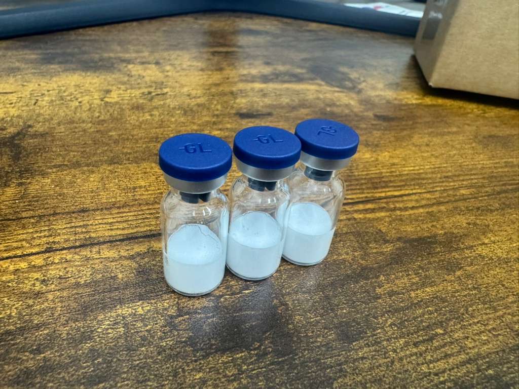 Three customer peptide vials with white lyophilized cakes after freeze drying